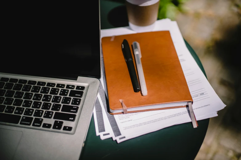 a laptop computer sitting on top of a table next to a cup of coffee, unsplash, pen and paper, multiple stories, stacked image, brown