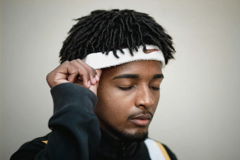 a man with dreadlocks adjusts his hair, inspired by Zhu Da, trending on pexels, hurufiyya, wearing the number 1 headband, loosely cropped, tapered hairline, teddy fresh