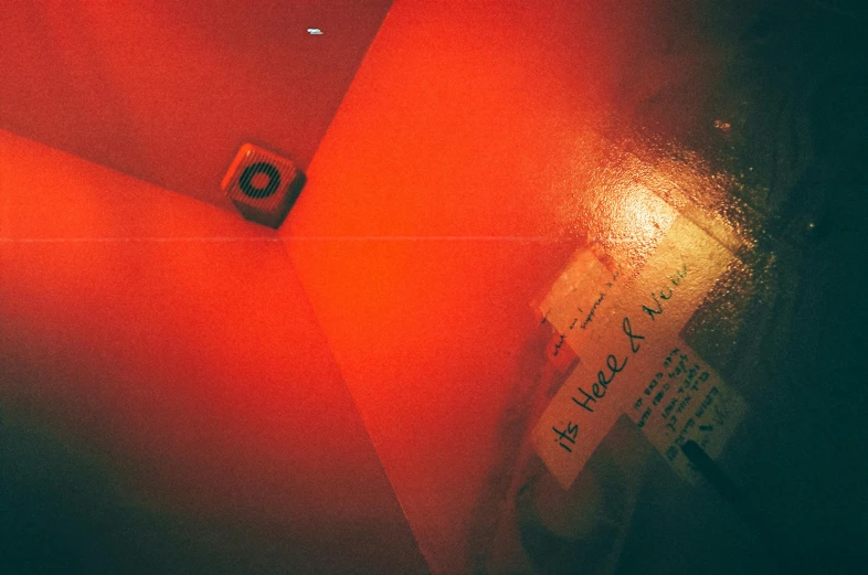 a red umbrella sitting on top of a floor, an album cover, inspired by Elsa Bleda, unsplash contest winner, serial art, underground room, lit. 'the cube', camera looking down upon, red light