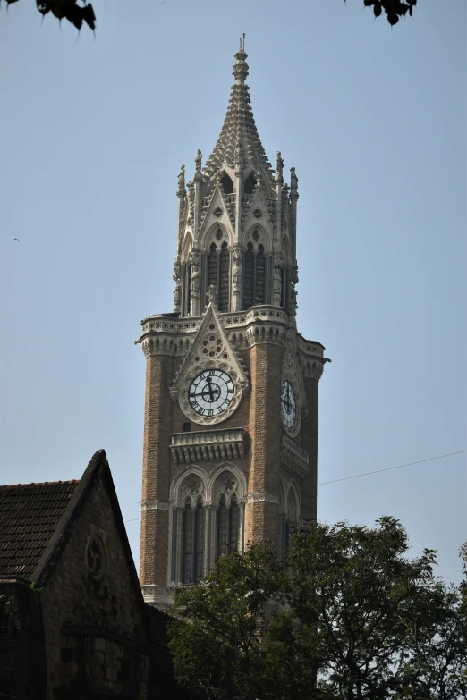 a tall tower with a clock at the top of it, bengal school of art, gothic revival, marilyn church h, zoomed in shots, view from front