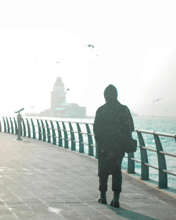 a person standing on a pier next to the ocean, snowing outside, istanbul, lgbtq, background image