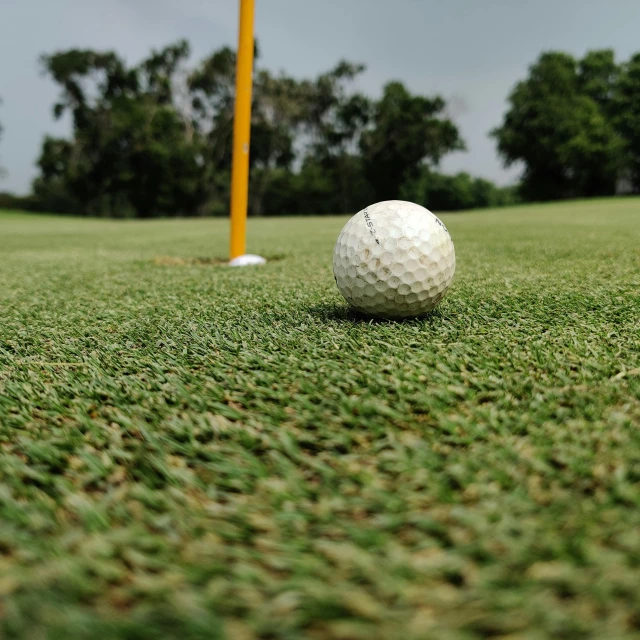 a golf ball sitting on top of a green field