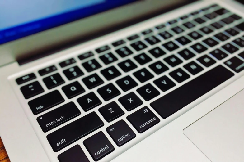 a laptop computer sitting on top of a wooden table, by Carey Morris, pexels, mechanical keyboard, high detailed close up of, apple, shot from below