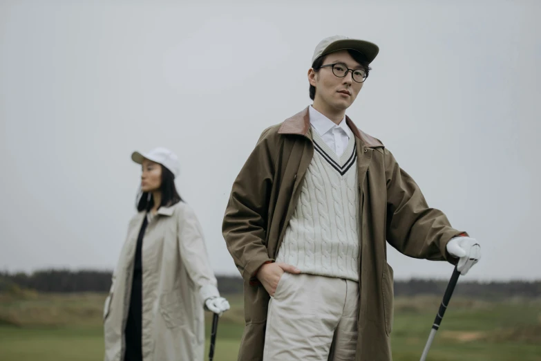 a couple of people standing next to each other on a field, unsplash, serial art, golf course, japanese live-action movie, brown clothes, portrait n - 9