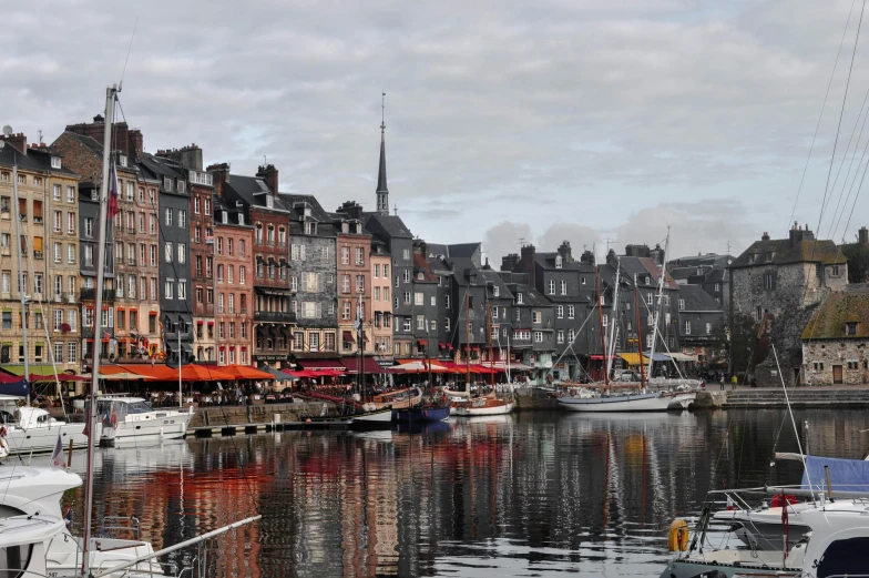 a harbor filled with lots of boats next to tall buildings, a photo, pexels contest winner, art nouveau, french village exterior, payne's grey and venetian red, normandy, listing image