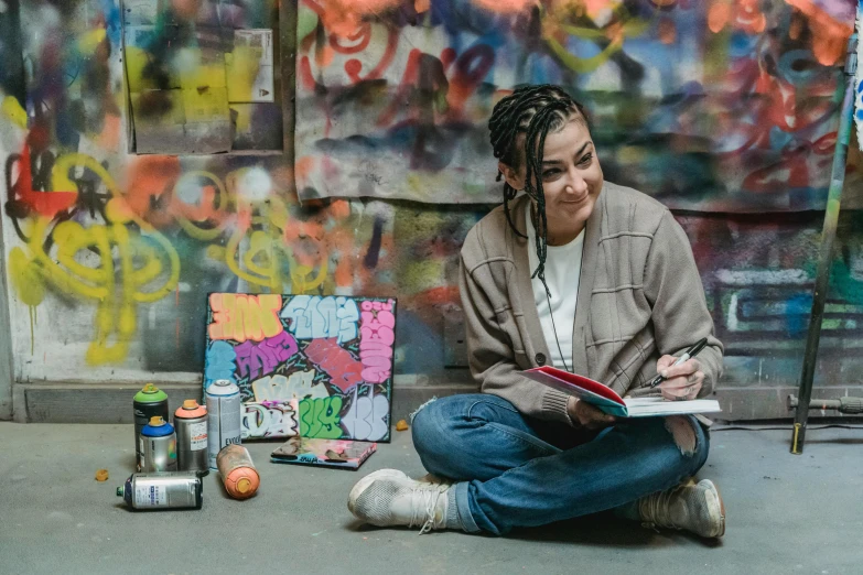 a woman sitting on the ground reading a book, a portrait, pexels contest winner, arbeitsrat für kunst, splashed with graffiti art, portrait of crazy post malone, in a studio, looking happy