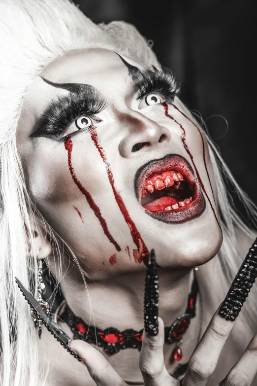 a woman with white hair and blood on her face, an album cover, inspired by Hedi Xandt, trending on pexels, with fangs, drag, bloody scene, lgbtq