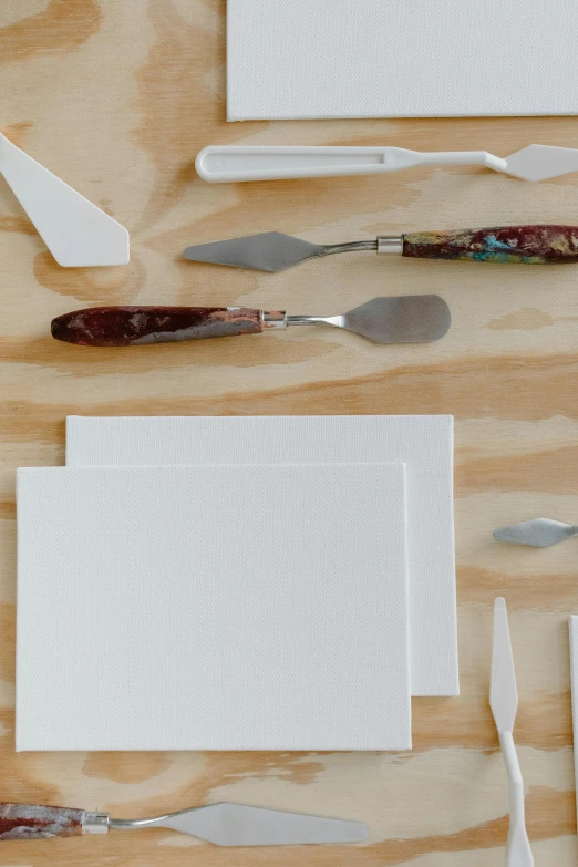 a table topped with lots of different types of utensils, inspired by Kyffin Williams, unsplash, process art, parchment paper, white finish, knives, studio product shot