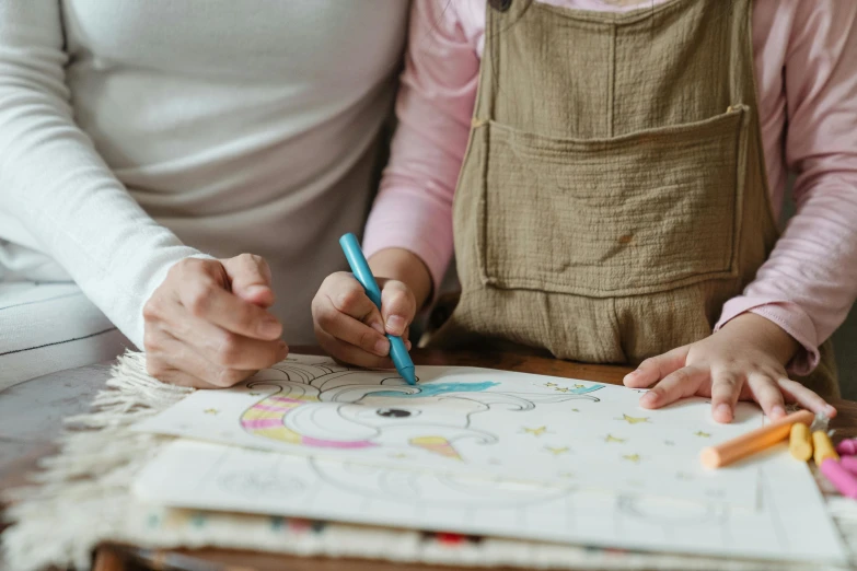 a woman and a child are drawing on a piece of paper, a child's drawing, by Julia Pishtar, pexels contest winner, artist wearing overalls, colouring - in sheet, brown, charts