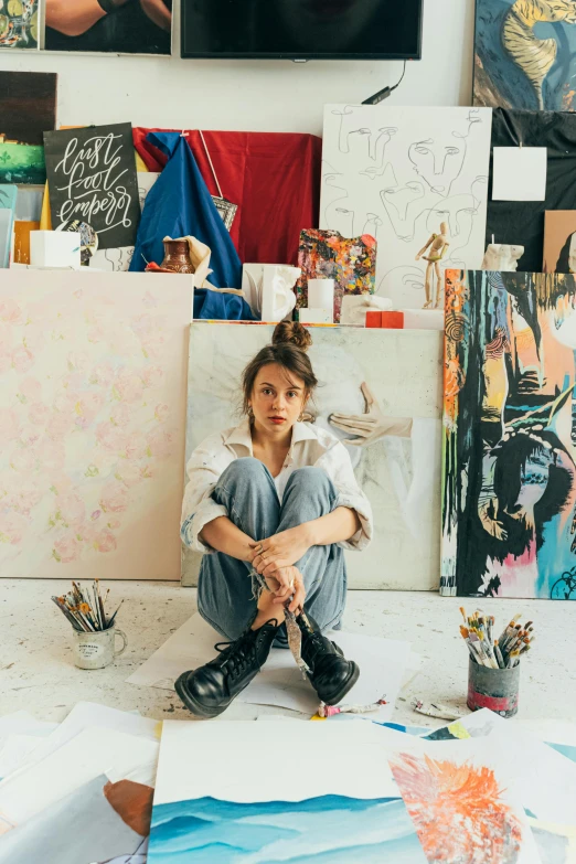 a woman sitting on the floor in front of a bunch of paintings, a portrait, trending on unsplash, arbeitsrat für kunst, painted overalls, anastasia ovchinnikova, art station”, high-quality photo