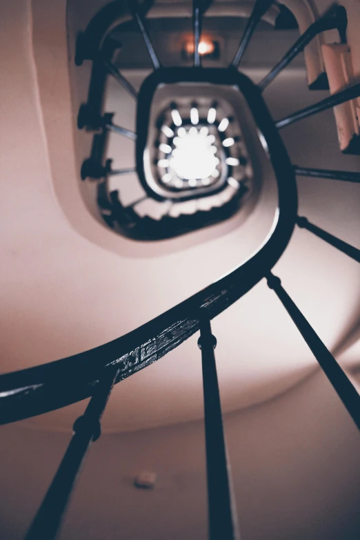 a spiral staircase with a clock at the top, inspired by André Kertész, pexels contest winner, art nouveau, blurred detail, looking down at you, delightful surroundings, in the evening
