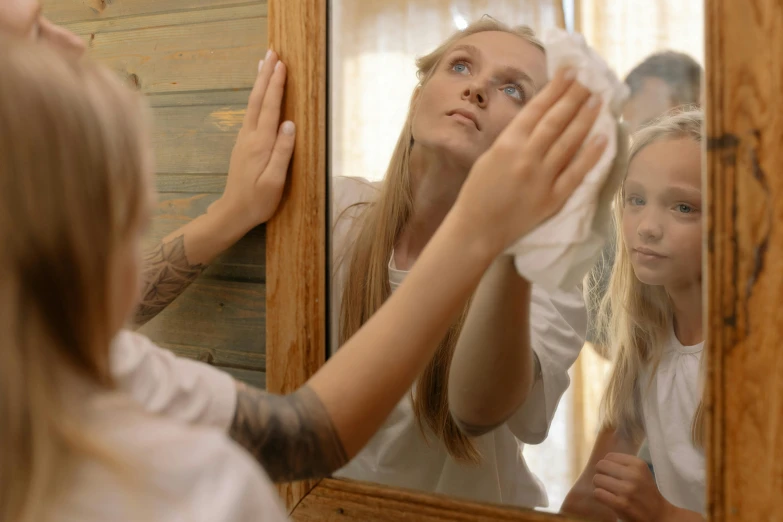 a woman brushing her hair in front of a mirror, pixabay, hyperrealism, caring fatherly wide forehead, dirt stains, a blond, teenage boy