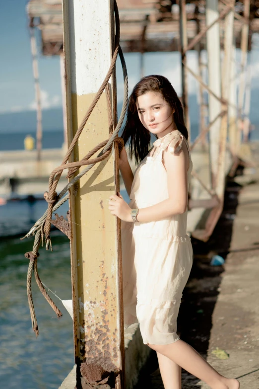 a woman standing on a pier next to a body of water, dilraba dilmurat, portrait image, vines, photography )