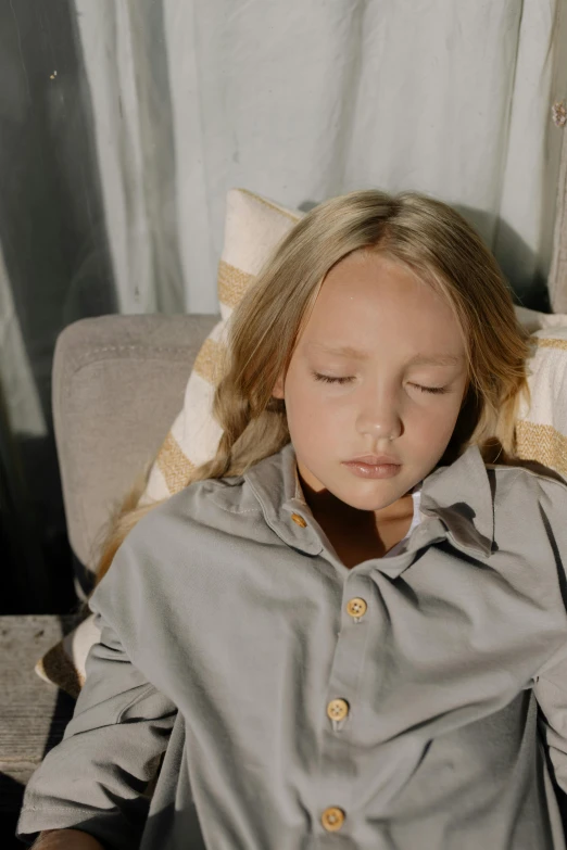 a little girl laying on a couch with her eyes closed, live-action archival footage, teen boy, shirt, grey