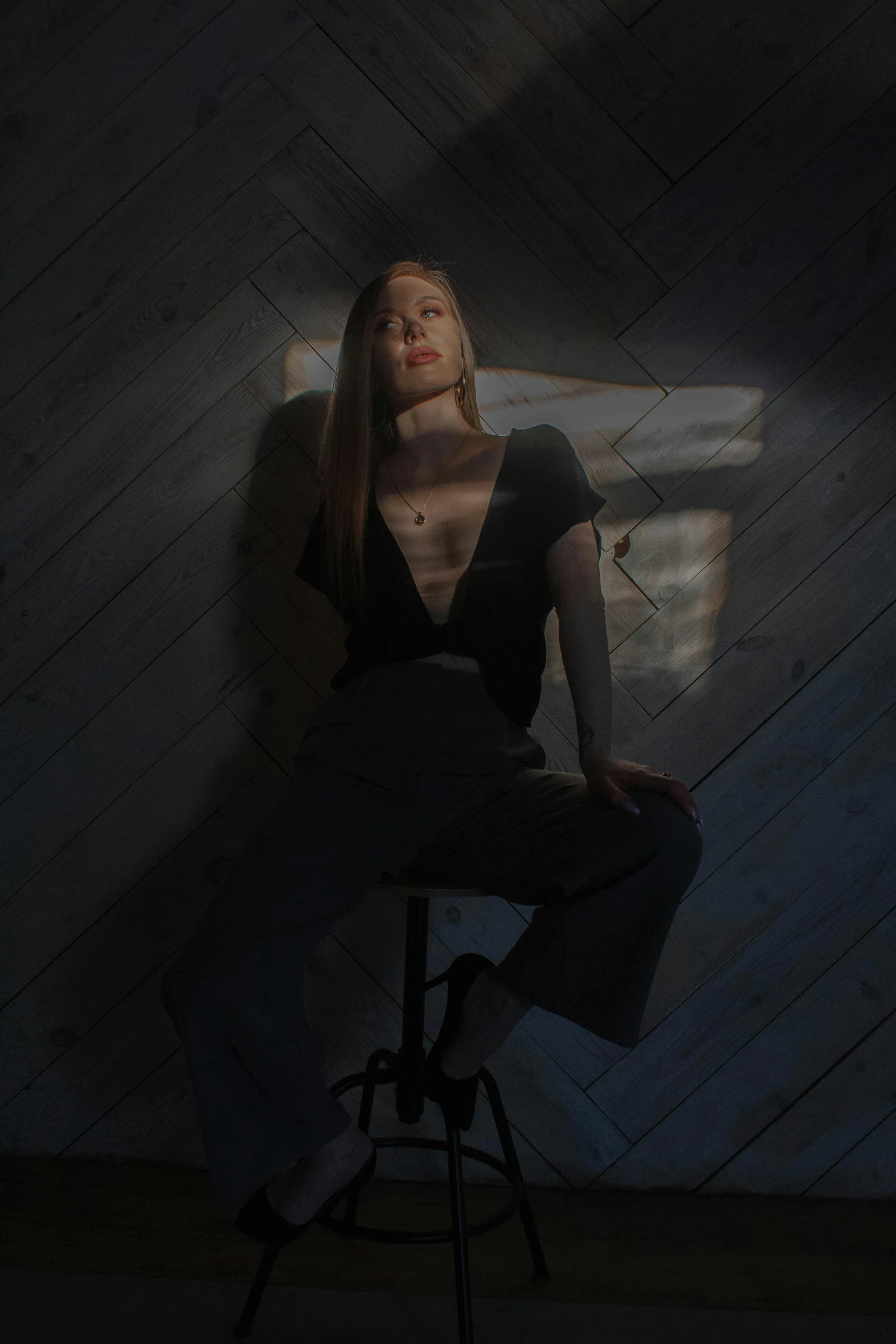 a woman sitting on a stool in a dark room, an album cover, inspired by Elsa Bleda, pexels contest winner, sun flare, britt marling style, pose model, instagram picture