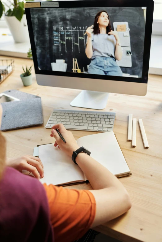 a woman sitting at a desk in front of a computer, a picture, trending on pexels, arbeitsrat für kunst, photo of a classroom, webcam screenshot, schematic in a notebook, full product shot