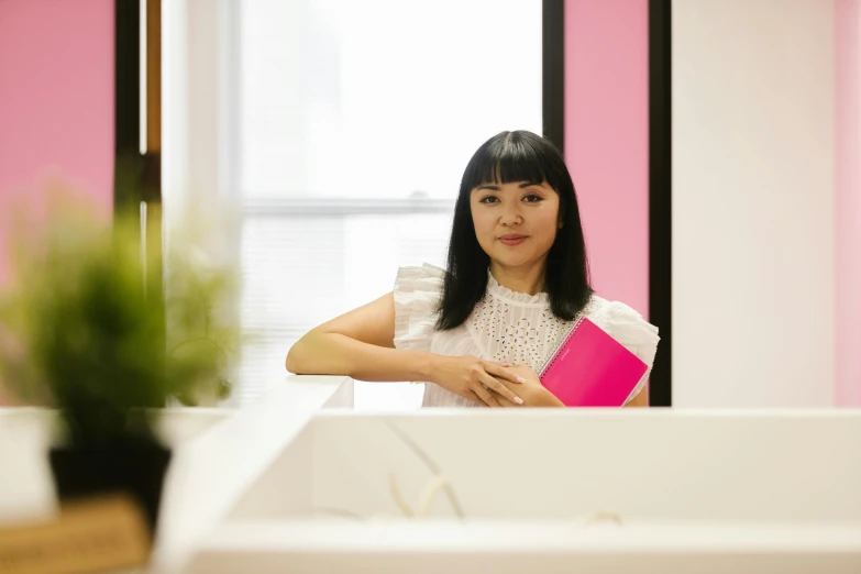 a woman sitting in a bathtub holding a pink book, inspired by Li Di, in a open-space working space, profile image, professional profile photo, asian origin