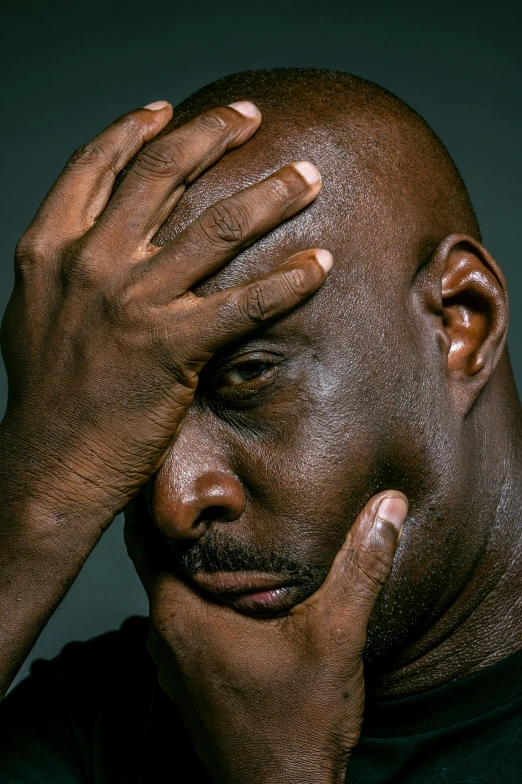 a man holding his head in his hands, by Paul Davis, lance reddick, exhausted face close up, huell babineaux, photo for magazine