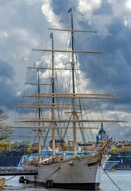 a large boat sitting on top of a body of water, a photo, inspired by Johan Christian Dahl, romanticism, three masts, at the waterside, spire, front shot