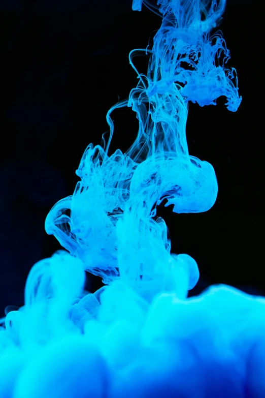 a close up of a blue substance in water, inspired by Kim Keever, pexels contest winner, neon smoke, black light, white thick smoke, with a blue background