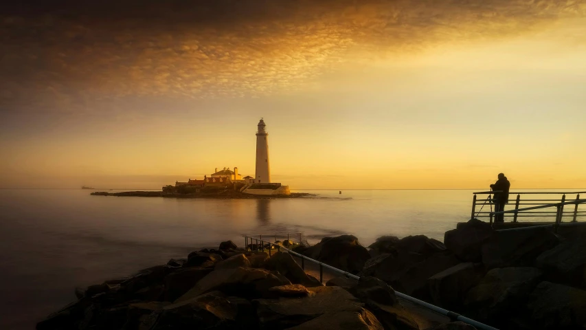 a couple of people standing on top of a pier, by Eglon van der Neer, unsplash contest winner, romanticism, bold lighthouse in horizon, yorkshire, sunny amber morning light, photo taken from a boat