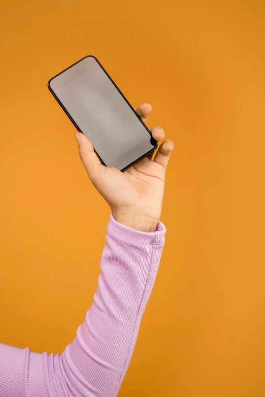 a close up of a person holding a cell phone, a picture, pink and orange, no - text no - logo, square, plain background