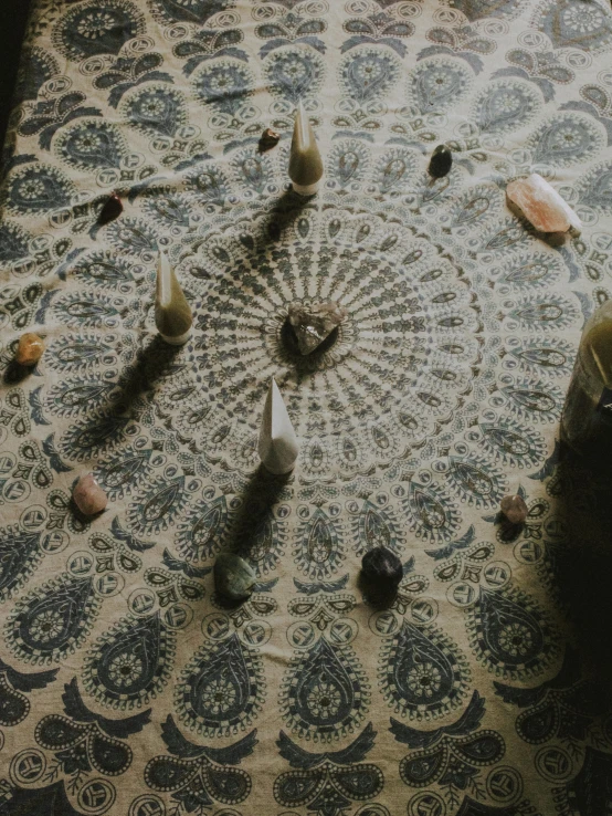 a group of candles sitting on top of a table, lying on a mandala, alessio albi, organic crystals, [ overhead view of a table ]!!