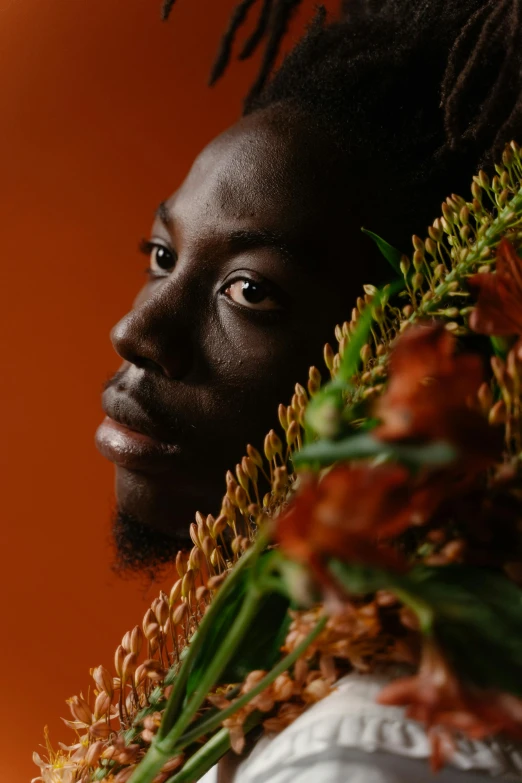 a man with dreadlocks holding a bunch of flowers, inspired by Ras Akyem, trending on unsplash, afrofuturism, black and terracotta, woman made of plants, portrait close up of guy, adut akech