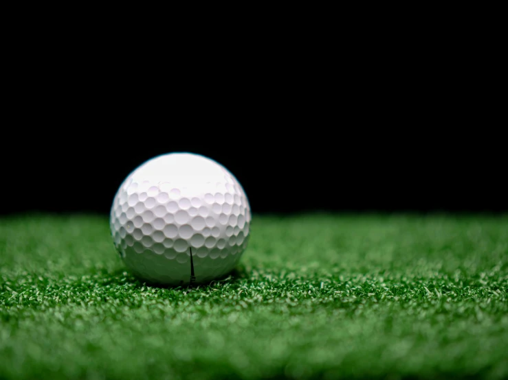 a golf ball sitting on top of a lush green field