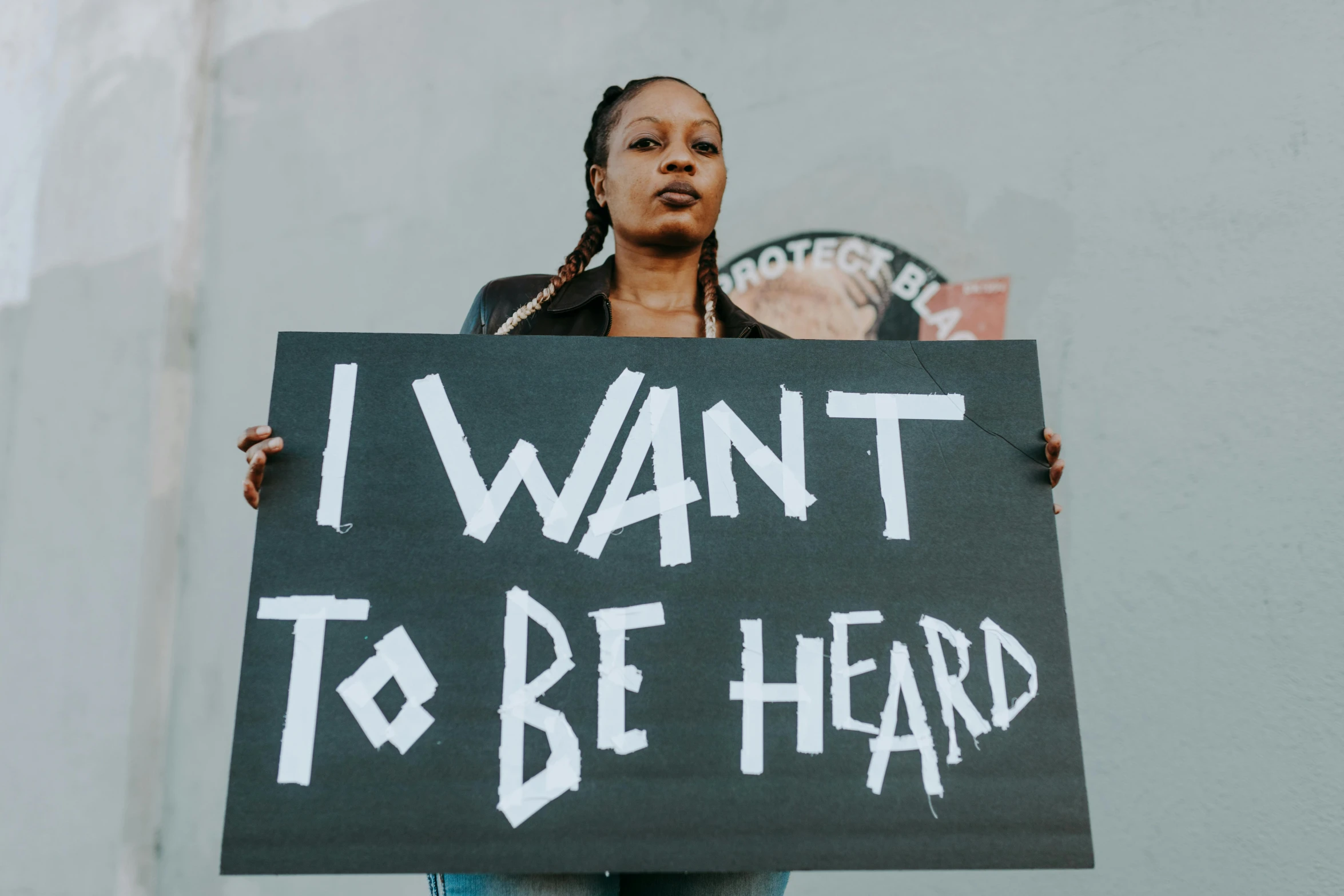 a woman holding a sign that says i want to be heard, trending on pexels, black arts movement, tinnitus, profile image, hot topic, ready