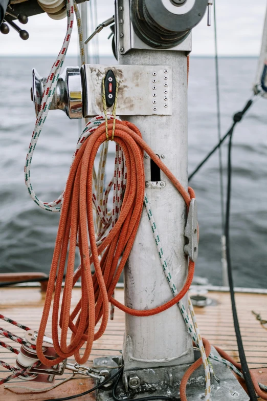 a close up of a boat on a body of water, cords, standing on the mast, bright and moody, hoses