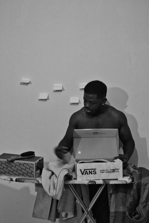 a black and white photo of a man on an ironing board, an album cover, by Justus van Gent, black skin!!!, sneakers, vhs footage still, vanta blac