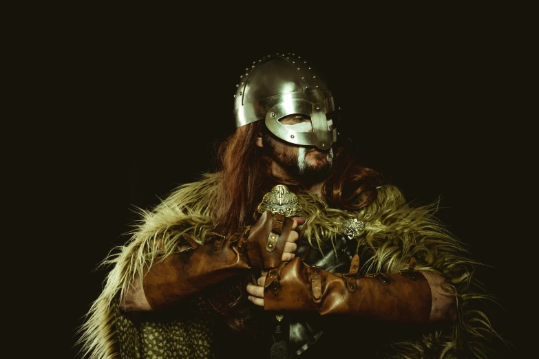 a man dressed as a viking holding a sword, inspired by Þórarinn B. Þorláksson, pexels contest winner, renaissance, silver and gold heavy armor, wearing barbarian caveman pelt, iron mask and helmet, low-key