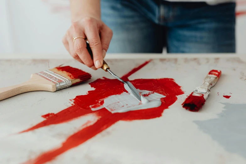 a person that has some paint on a table, inspired by Robert Motherwell, trending on pexels, action painting, silver and crimson ink, paintbrush, screen printing, amanda lilleston