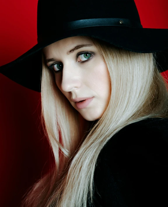 a woman with long blonde hair wearing a black hat, an album cover, inspired by Julia Pishtar, pexels contest winner, red contact lenses, lovingly looking at camera, dark. no text, square