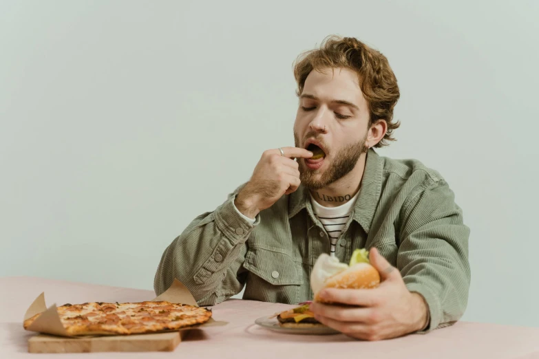 a man sitting at a table eating a sandwich, pexels contest winner, buttercup eating pizza, hozier, lachlan bailey, starving artist wearing overalls