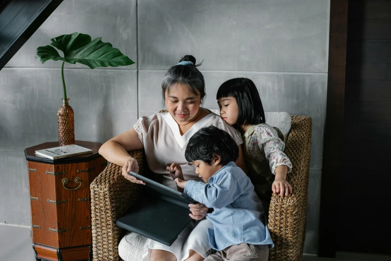 a woman and two children sitting in a chair, pexels contest winner, holding notebook, an asian woman, profile image, maintenance photo