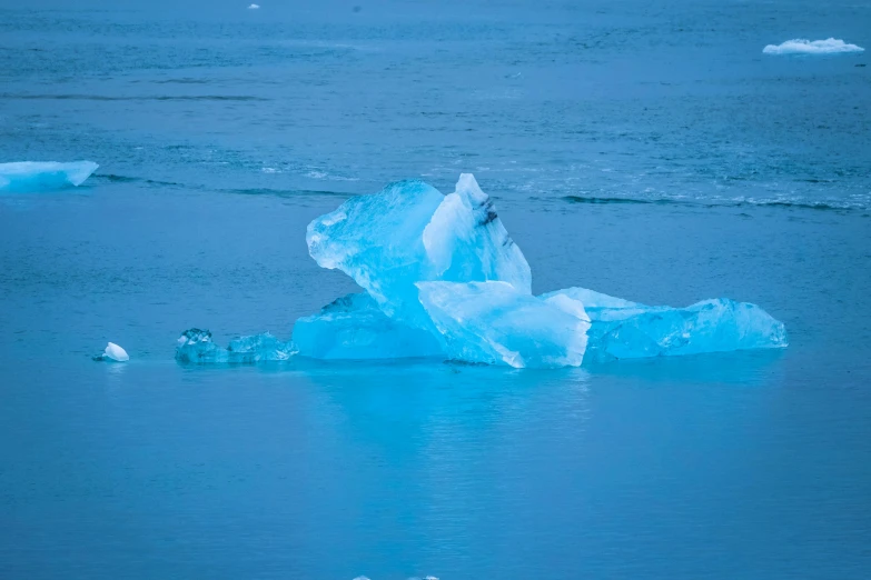 an iceberg floating on top of a body of water, pexels contest winner, visual art, freezing blue skin, 2022 photograph, reykjavik, neon blue color