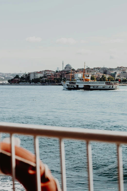 a person taking a picture of a boat in the water, istanbul, 🚿🗝📝, panorama view, unsplash photography