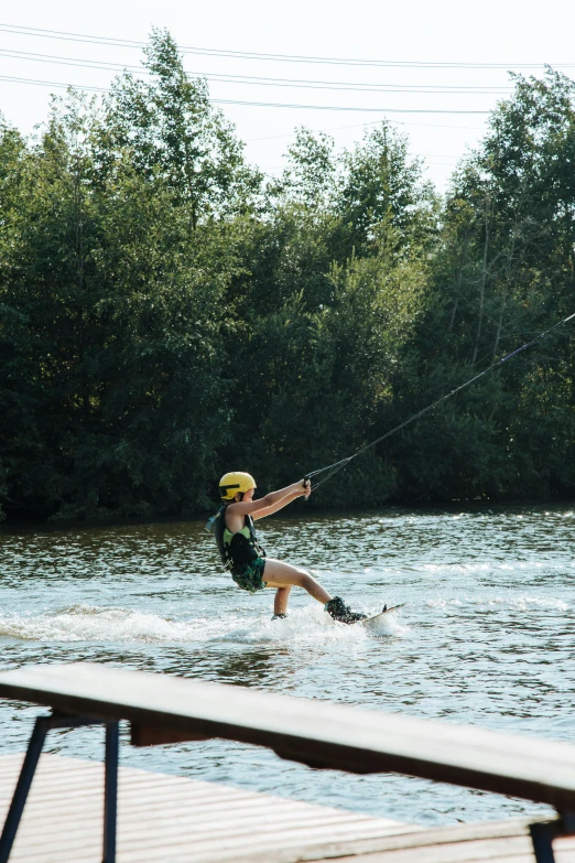 a man riding water skis on top of a lake, swing on a tree, she is walking on a river, in the sun, fierce - looking