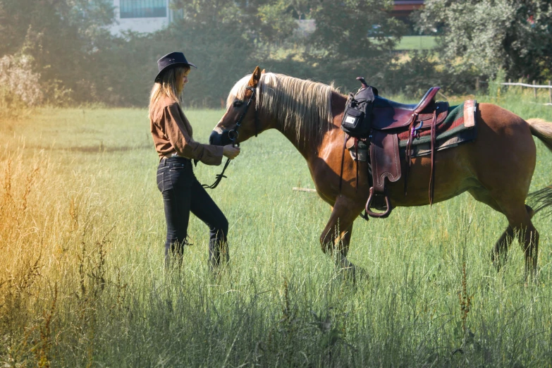 a woman standing next to a horse in a field, inspired by Rosa Bonheur, pexels contest winner, high tech saddle, wearing cowboy hat, urban surroundings, green pastures stretch for miles