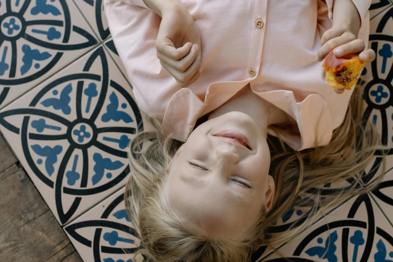 a little girl laying on the floor eating a piece of pizza, trending on unsplash, symbolism, lying on a mandala, still frame from a movie, smiling playfully, looking upwards