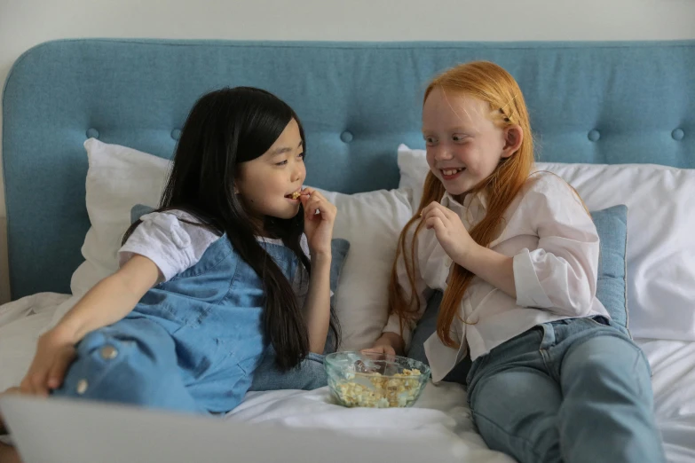 a couple of girls sitting on top of a bed, inspired by Elsa Beskow, pexels contest winner, incoherents, eating chips and watching tv, cute young redhead girl, asian female, avatar image