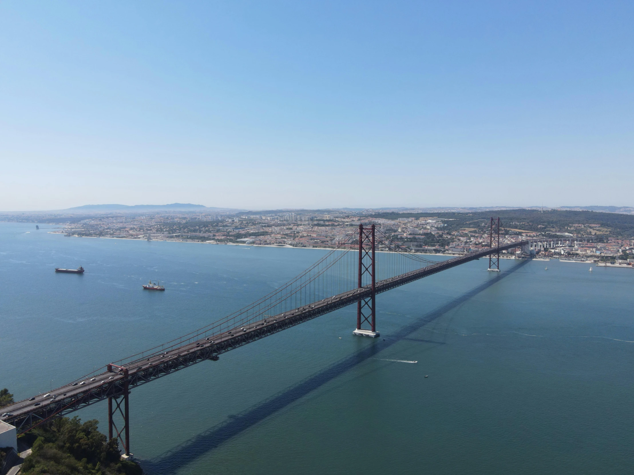 a large bridge over a large body of water, a picture, inspired by Almada Negreiros, pexels contest winner, hurufiyya, clear blue skies, helicopter view, slide show, soaring towers and bridges