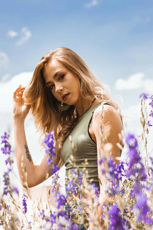 a woman standing in a field of purple flowers, a colorized photo, trending on pexels, portrait of vanessa morgan, sydney sweeney, fashion shoot 8k, handsome girl