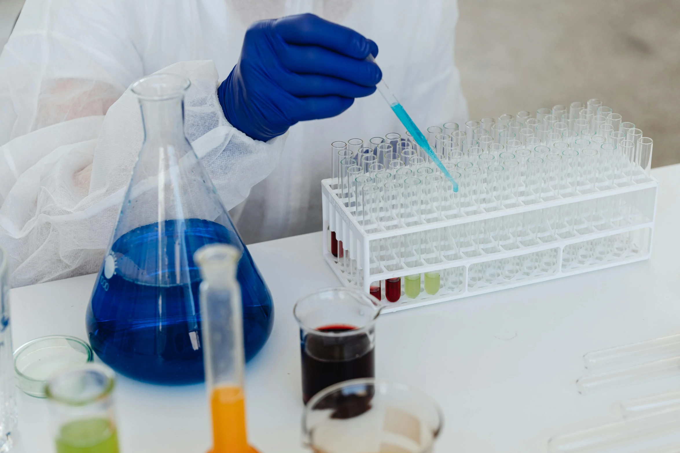 a close up of a person in a lab coat, pexels, analytical art, ingredients on the table, black and blue and purple scheme, clean white lab background, brown