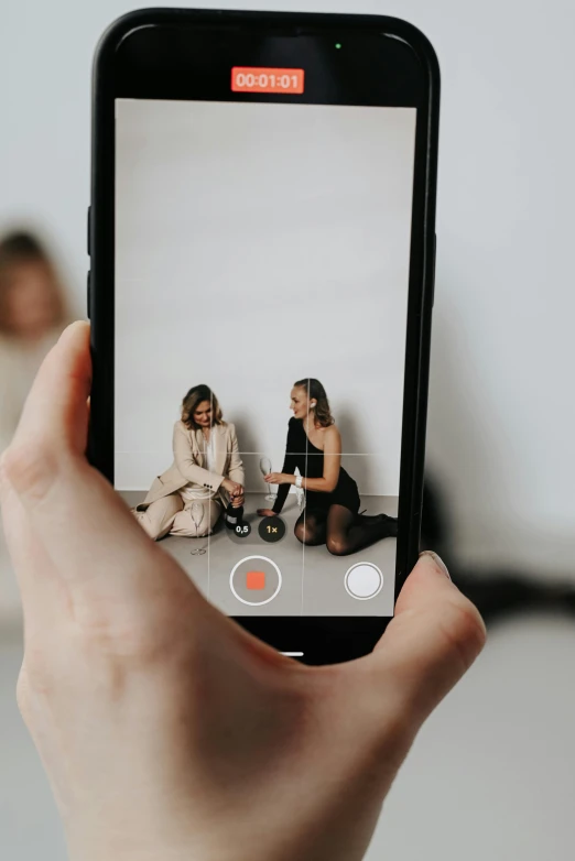 a person taking a picture with a cell phone, two models in the frame, unsplash transparent, low quality video, digital image