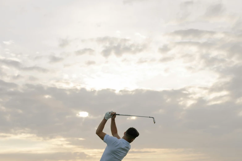 a man swinging a golf club on a cloudy day, unsplash, avatar image, evening lighting, bottom angle, medium angle