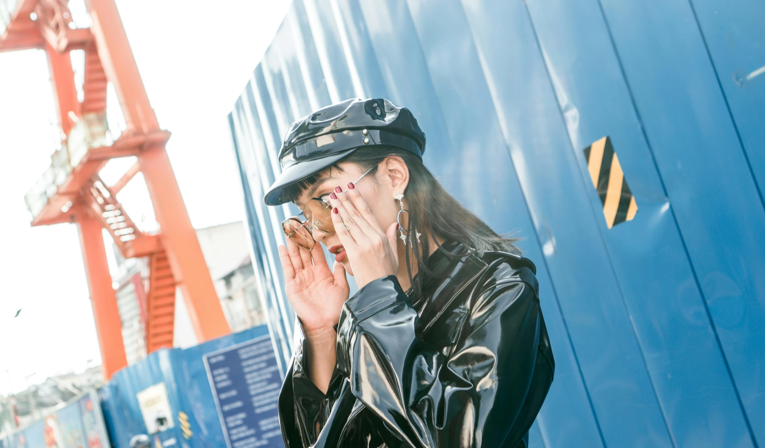 a woman in a black leather jacket talking on a cell phone, an album cover, by Julia Pishtar, unsplash, sleek blue visor for eyes, japanese streetwear, glossy shiny reflective, hand holding cap brim