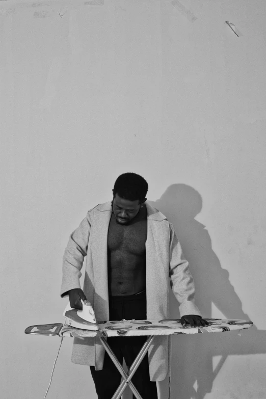 a black and white photo of a man ironing, an album cover, by Ras Akyem, conceptual art, wearing a labcoat, body builder, ( ( photograph ) ), made of wax and oil